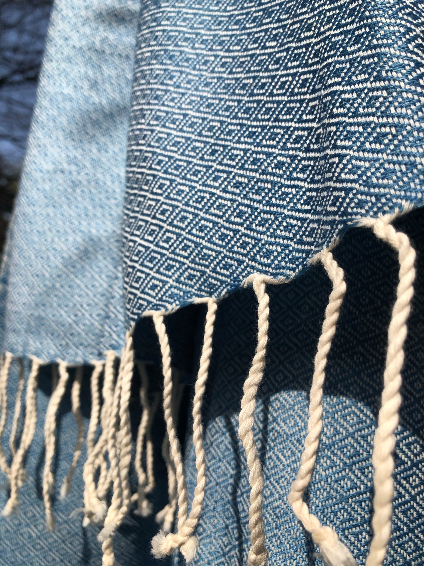 Light blue scarf shines in sunlight.