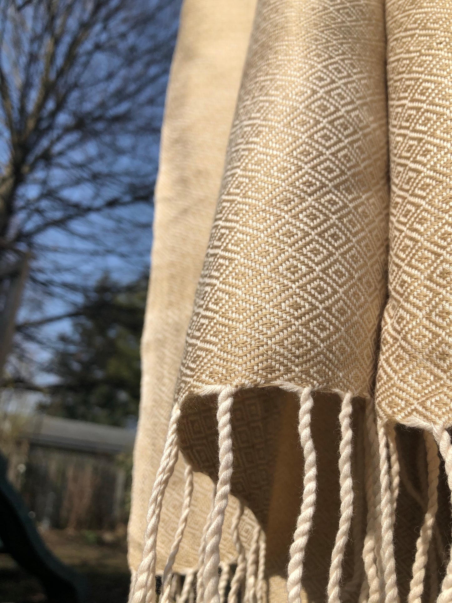 Light ecru scarf shines in sunlight.